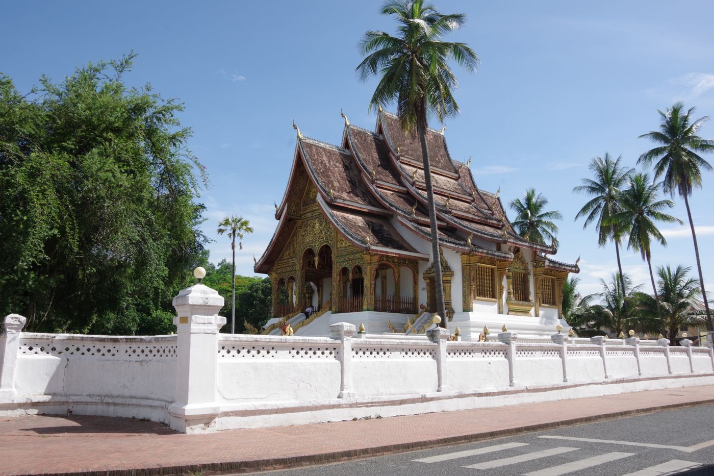 The Royal Palace in Luang Prabang, Laos, framed by palm trees