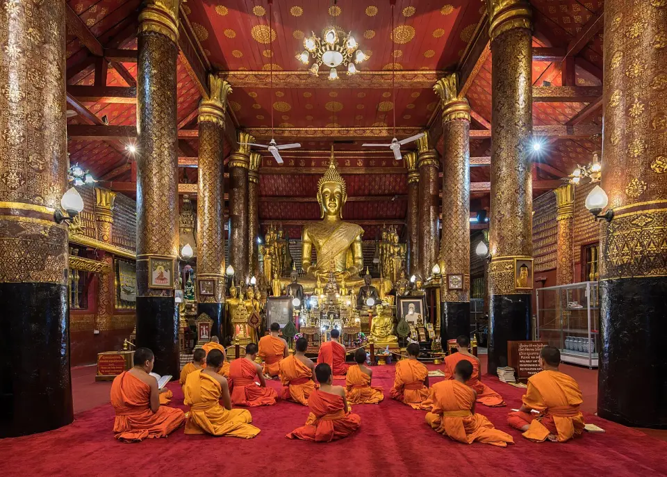 Monks praying inside Wat Mai Suwannaphumaham